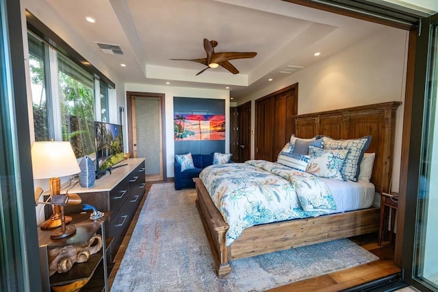 bedroom featuring ceiling fan and a tray ceiling