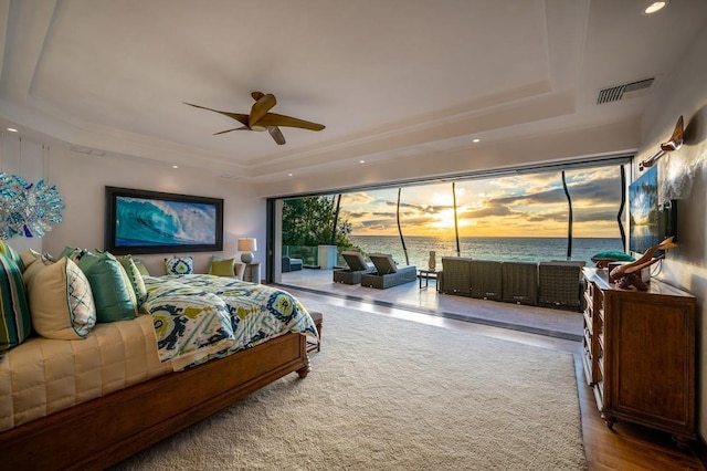 bedroom with ceiling fan and a tray ceiling