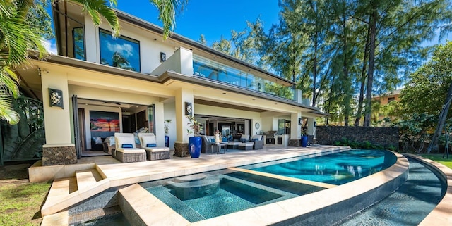 back of house with a swimming pool with hot tub, outdoor lounge area, and a patio area