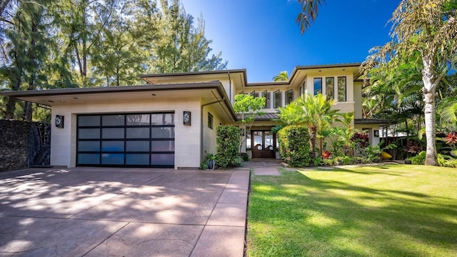 view of front of home with a front yard and a garage