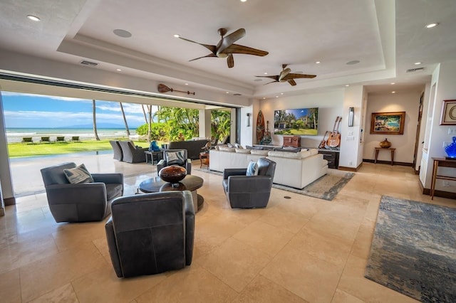 living room with a water view and a raised ceiling