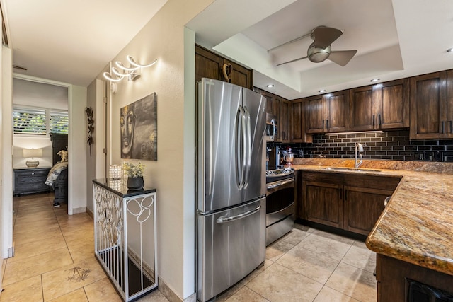 kitchen featuring dark brown cabinetry, sink, light tile patterned floors, stainless steel appliances, and backsplash