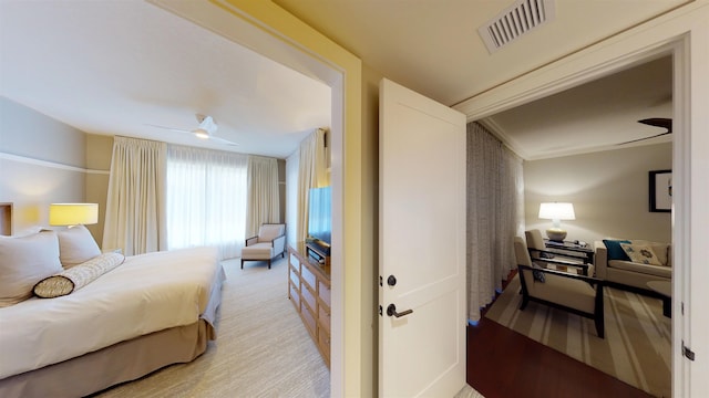 bedroom with light carpet, visible vents, and ceiling fan