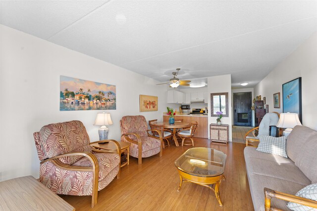 living room featuring light hardwood / wood-style flooring and ceiling fan