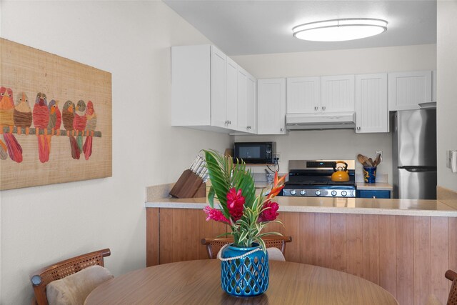 kitchen with kitchen peninsula, white cabinets, and appliances with stainless steel finishes