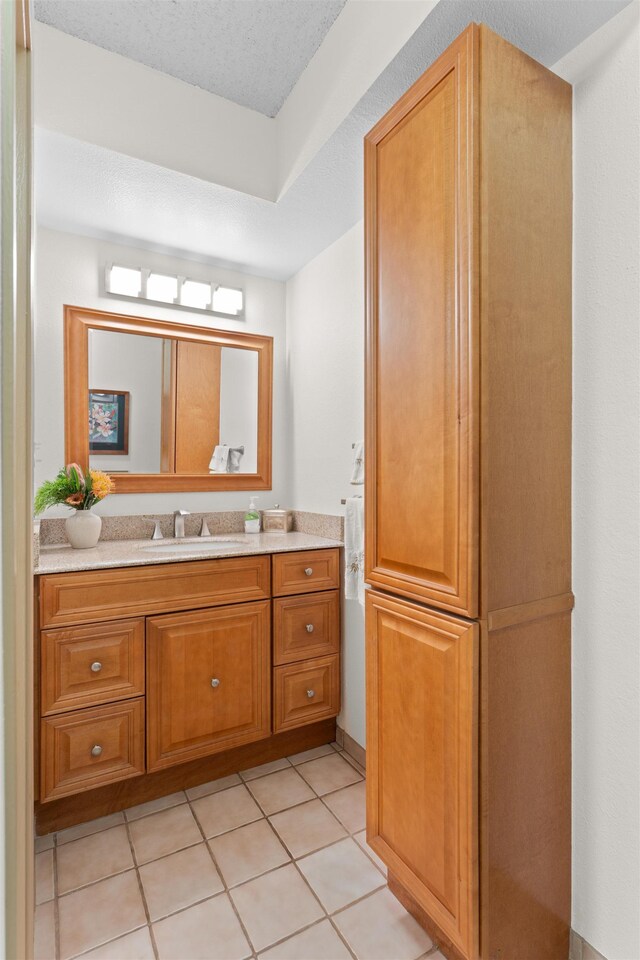 bathroom featuring tile patterned flooring, vanity, and a textured ceiling