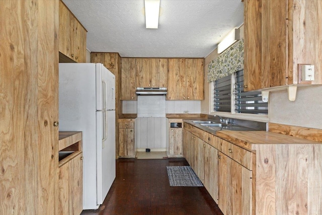 kitchen featuring sink, a textured ceiling, and white refrigerator