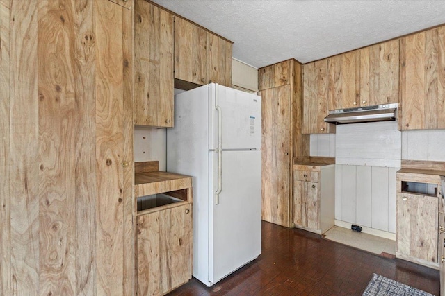 kitchen featuring white refrigerator and a textured ceiling