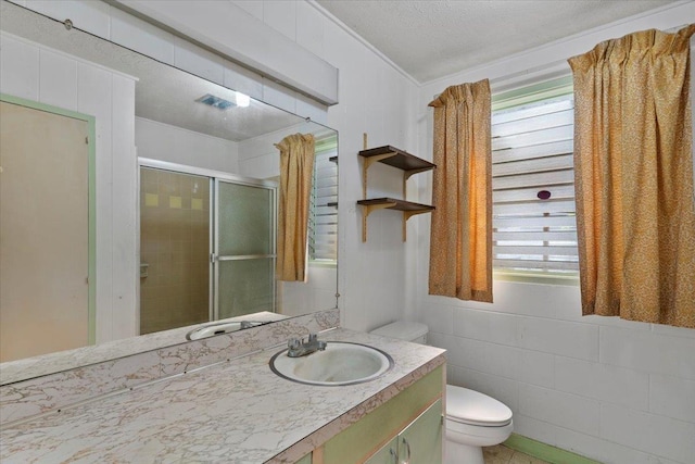 bathroom with an enclosed shower, vanity, plenty of natural light, and toilet