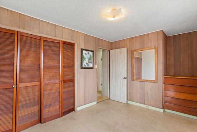 unfurnished bedroom featuring a closet and wood walls