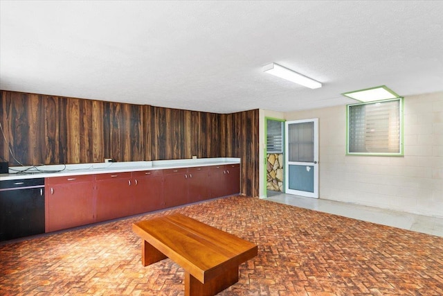 interior space with wooden walls and a textured ceiling