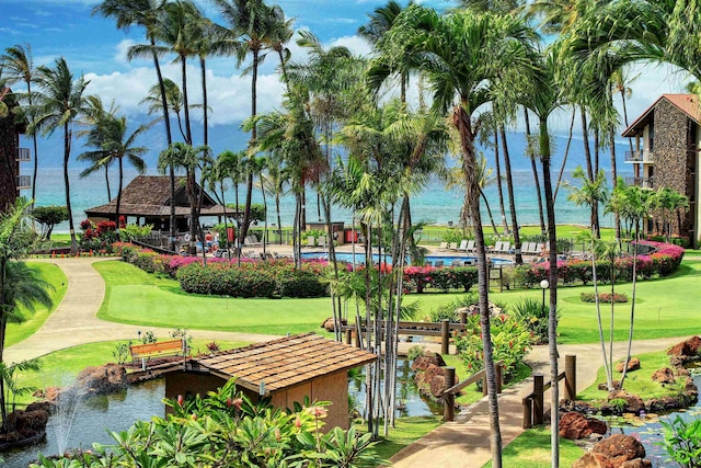 view of community featuring a swimming pool, a gazebo, a lawn, and a water view