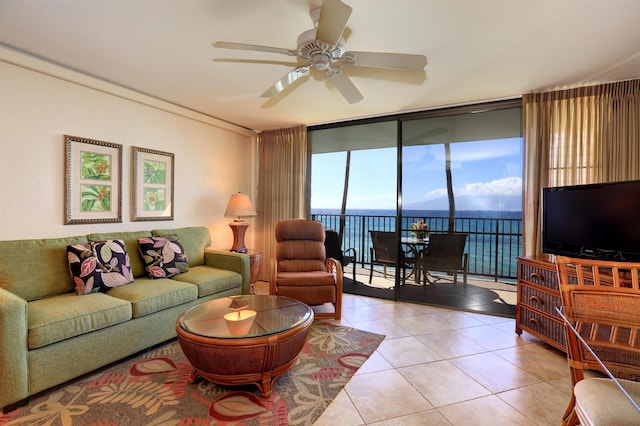 living room featuring ceiling fan, light tile patterned flooring, and expansive windows