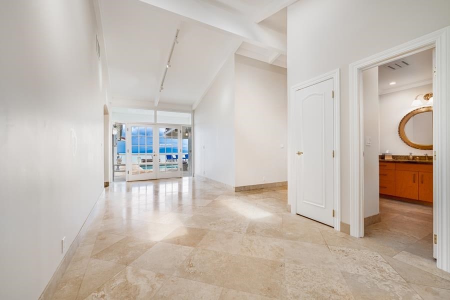 hallway with french doors, track lighting, and light tile flooring