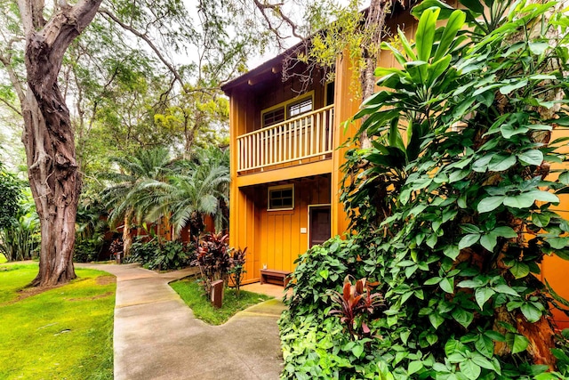 exterior space with a balcony and a front lawn