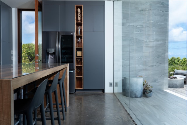 kitchen with a breakfast bar area and stainless steel fridge