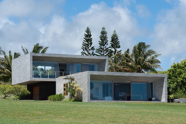 rear view of property with a balcony and a yard