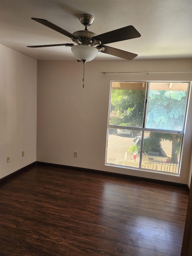 empty room with dark hardwood / wood-style flooring and ceiling fan