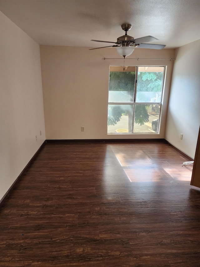 spare room with a textured ceiling, dark hardwood / wood-style floors, and ceiling fan