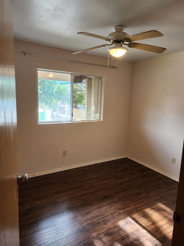 empty room with ceiling fan, dark hardwood / wood-style floors, and a textured ceiling