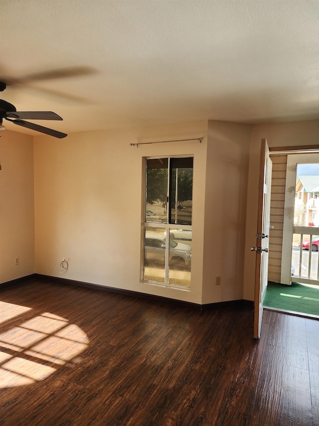 spare room featuring a wealth of natural light, ceiling fan, a textured ceiling, and dark hardwood / wood-style flooring