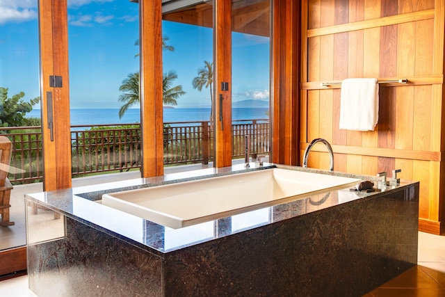 kitchen featuring stone counters, tile patterned flooring, and a water view