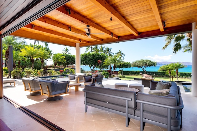 view of patio featuring ceiling fan, a water view, and an outdoor living space