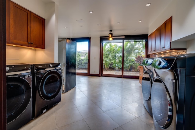 clothes washing area with cabinets, independent washer and dryer, and light tile patterned flooring