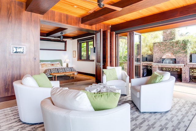 tiled living room featuring ceiling fan, wooden walls, beamed ceiling, and wood ceiling