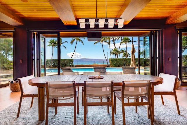 dining room featuring beamed ceiling, light hardwood / wood-style flooring, a water and mountain view, and wood ceiling