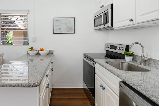 kitchen with light stone countertops, sink, stainless steel appliances, dark hardwood / wood-style flooring, and white cabinets