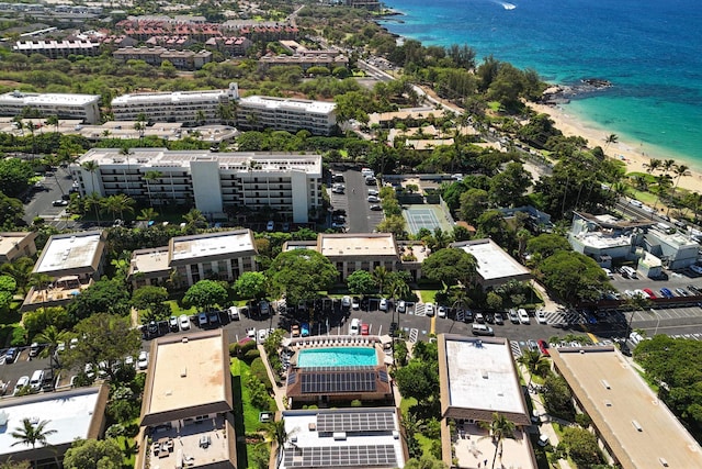 birds eye view of property with a water view and a beach view