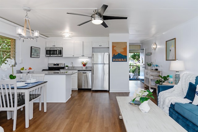 kitchen featuring white cabinets, decorative light fixtures, hardwood / wood-style floors, and appliances with stainless steel finishes