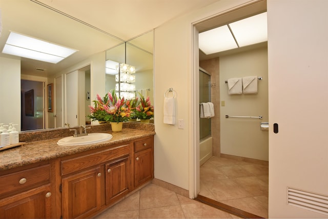 bathroom featuring tile patterned floors, vanity, and bath / shower combo with glass door