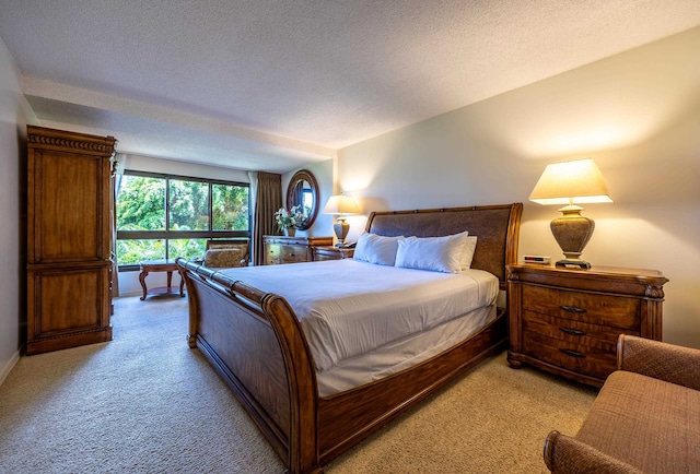 bedroom with light colored carpet and a textured ceiling