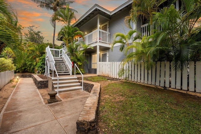 yard at dusk featuring a balcony