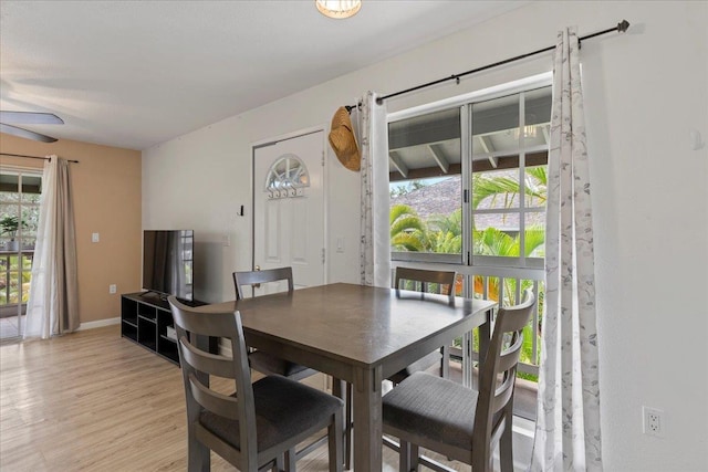 dining space featuring light wood-style flooring, baseboards, and ceiling fan