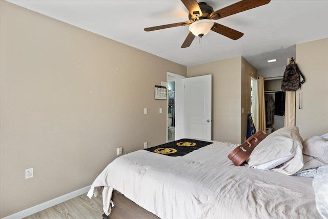 bedroom with light wood-type flooring, baseboards, and a ceiling fan