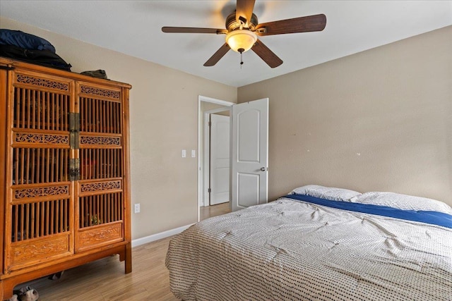 bedroom with a ceiling fan, light wood-type flooring, and baseboards