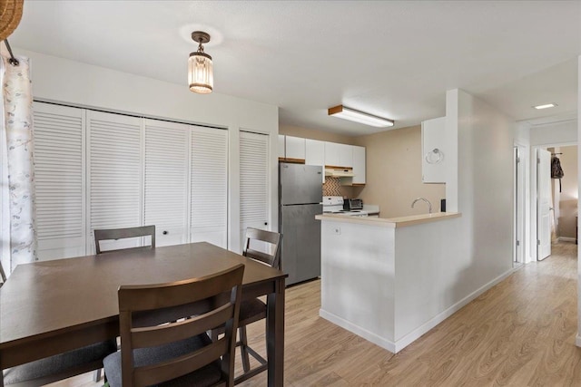 dining space with sink and light hardwood / wood-style floors