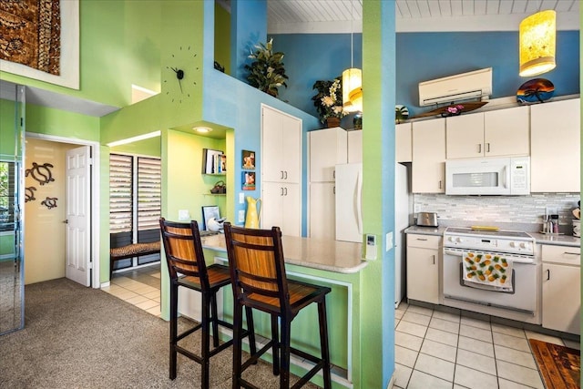 10 Wailea Ekolu Pl Unit 1008, Kihei, HI 96753 - kitchen featuring white appliances, a wall unit AC, white cabinets, light tile patterned floors, and tasteful backsplash