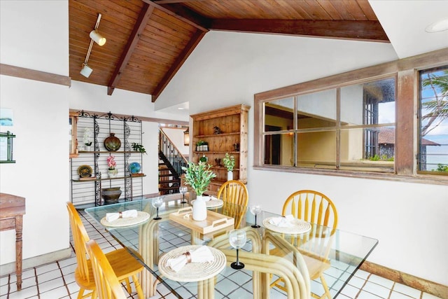 tiled dining area featuring wooden ceiling, lofted ceiling with beams, and rail lighting