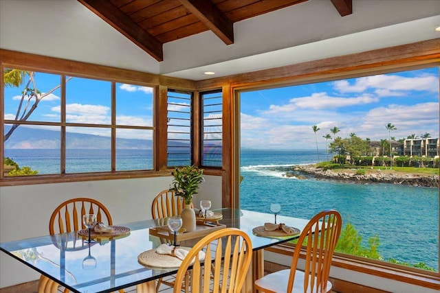 dining space featuring a water view, vaulted ceiling with beams, and wooden ceiling