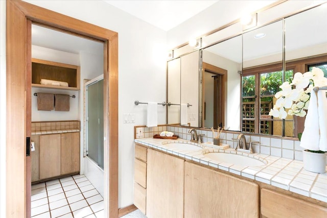 bathroom featuring enclosed tub / shower combo, vanity, and tile patterned flooring