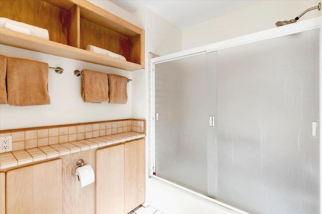 bathroom featuring shower / bath combination with glass door