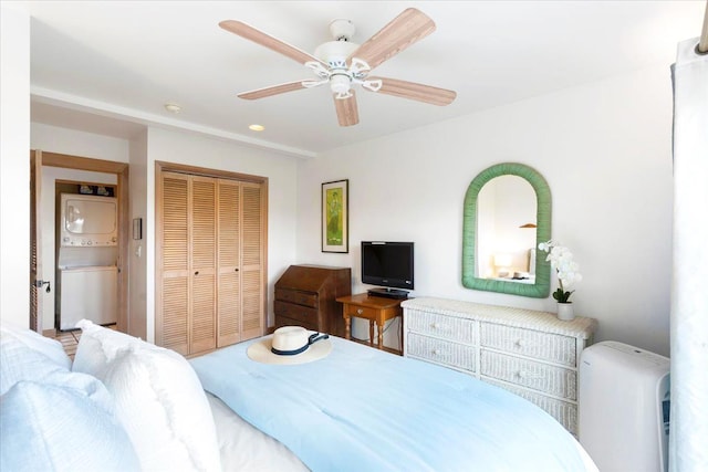 bedroom with ceiling fan, stacked washer / drying machine, and a closet