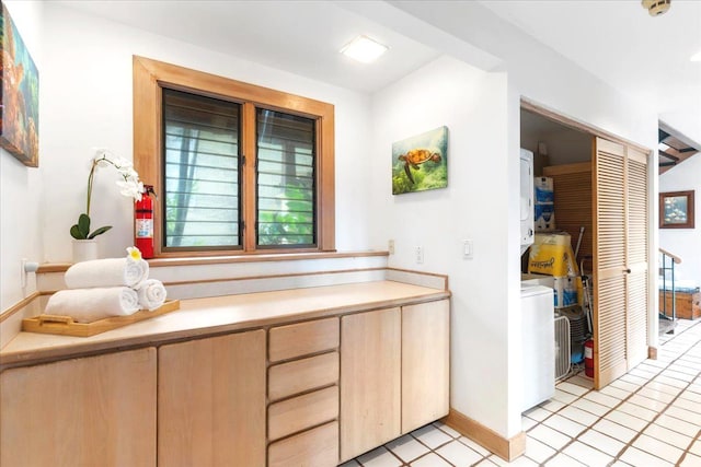 interior space with light brown cabinetry, washer / clothes dryer, and light tile patterned flooring