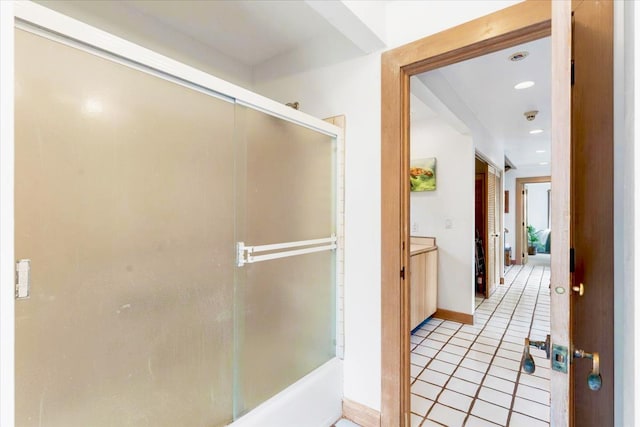 bathroom featuring a shower with shower door, vanity, and tile patterned flooring