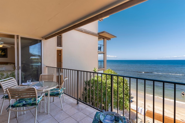 balcony featuring a view of the beach and a water view