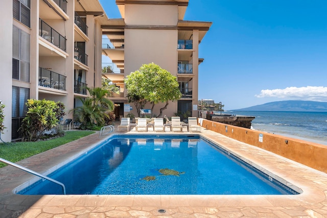 view of pool with a water and mountain view and a patio area